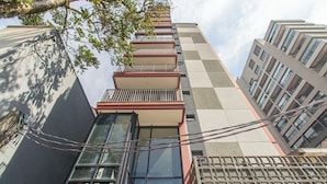 Un edificio de gran altura con múltiples balcones y ventanas amplias.
