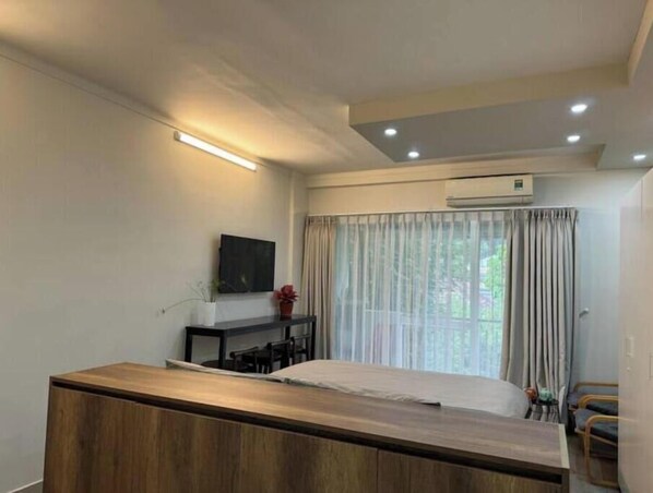 A bedroom with a bed, a desk, a chair, and a TV on the wall. - 57P3F-SweetHeart in SaiGon (Thành phố Hồ Chí Minh)