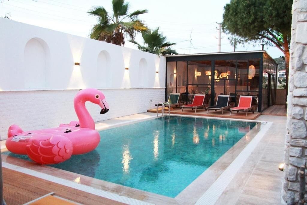 En säsongsöppen utomhuspool, parasoller och solstolar