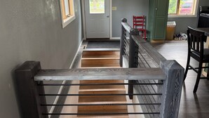 A staircase with a wooden handrail leading to a door. - Rogers Creekside Ranch - Wessington Springs, SD - 3+ Bed, 1 Bath (Wessington Springs)