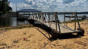 A metal bridge over water with a covered structure on the left. - Dockside Dreamz- Full duplex lake fun for 12 (Clarksville)