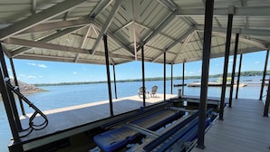 A covered dock with a pool table, chairs, and a view of the water. - Dockside Dreamz- Full duplex lake fun for 12 (Clarksville)