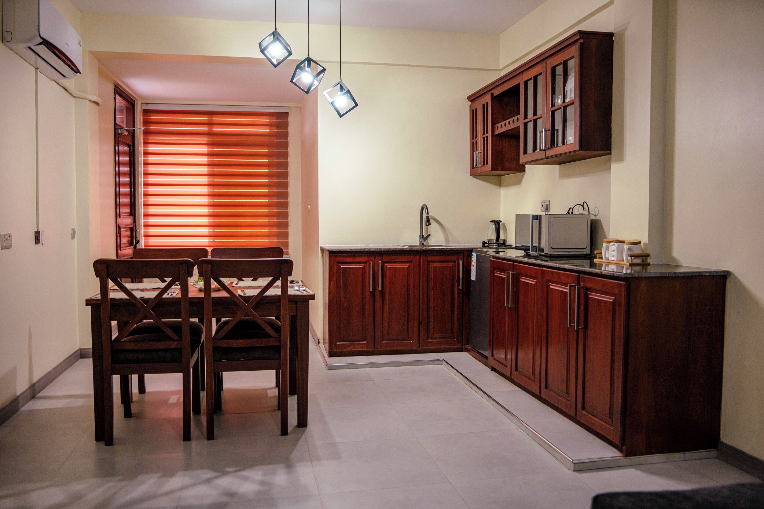 Una cocina compacta con armarios de madera, una mesa de comedor con sillas y un horno empotrado.