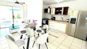 A modern kitchen with a dining area, stainless steel appliances, and a view of the outdoors. - Welcome to your tropical getaway! 6 people (Herradura)