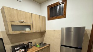 Uma cozinha com armários de madeira, geladeira de aço inoxidável, micro-ondas e fogão a gás.