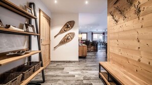 Ein modernes Interieur mit Holzböden, gewebten Körben und einem Essbereich mit Wand- und Deckenverzierungen aus Holz.