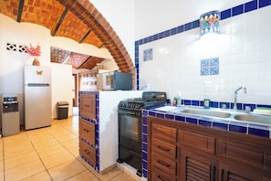 Una cocina equipada con refrigerador, estufa y lavabo.