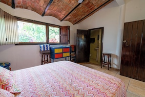 A bedroom with a bed, a desk, and a wardrobe.