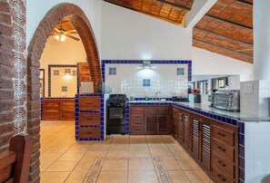 A kitchen with a central island, wooden cabinets, and a tiled backsplash.
