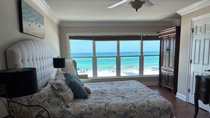 A bedroom with a large bed, a view of the ocean, and a ceiling fan. - Beach Front Townhome – 2 BR, 3 BA - Deck Overlooking Gulf & Steps to the Beach (Panama City Beach)