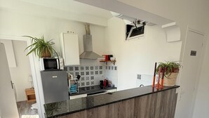 Une cuisine moderne dotée d’un îlot central, de tabourets de bar, d’un four à micro-ondes et d’une cuisinière.
