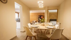 A dining area with a round table, white chairs, and a potted plant. - 350m from ski lifts, 1st floor, parking, 67m², Valloire (Valloire)
