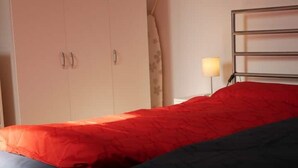 A bedroom with a bed, a wardrobe, and a bedside lamp. - Sunny apartment, 2 rooms (Looft)