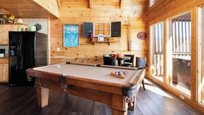 A wooden interior with a pool table, kitchen area, and large windows. - Memorable Mountain Views w/ Hot Tub (Sevierville)