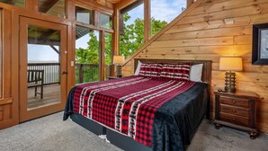 Une chambre avec un grand lit, des murs en bois et un balcon.