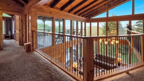 Un interior de madera con un balcón que ofrece vistas a un paisaje pintoresco.