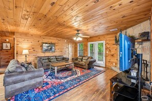 A wooden interior with two sofas, a coffee table, and a TV.