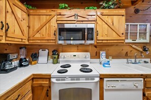 A kitchen with wooden cabinets, a microwave, a stove, and a dishwasher.