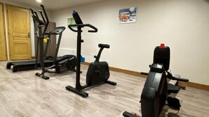 Ett hemmagym med löpband, crosstrainer och motionscykel.