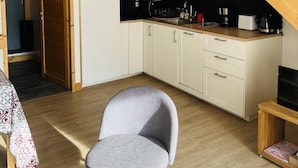 A compact kitchen with white cabinets, a microwave, and a wooden staircase. - 250m from ski slopes, 1st floor, terrace, parking, ski locker, 60m², Valloire (Valloire)