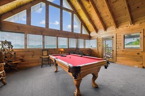 A wooden room with a pool table, large windows, and a view of the outdoors. - Romantic Log Cabin w/ Hot Tub & Views (Sevierville)