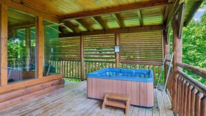 A wooden deck with a hot tub and a small wooden stool.