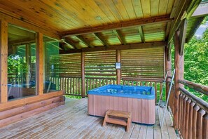 A wooden deck with a hot tub and a small wooden stool.