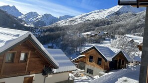 Un pueblo cubierto de nieve con casas de madera y un cielo azul despejado.