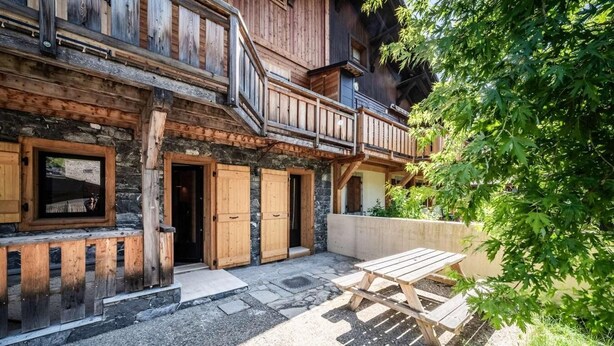 A rustic wooden building with a balcony, stone walls, and a wooden table in the courtyard. - 200m from ski lifts, Ground floor, terrace, parking, tv, 45m², Morzine (Morzine)
