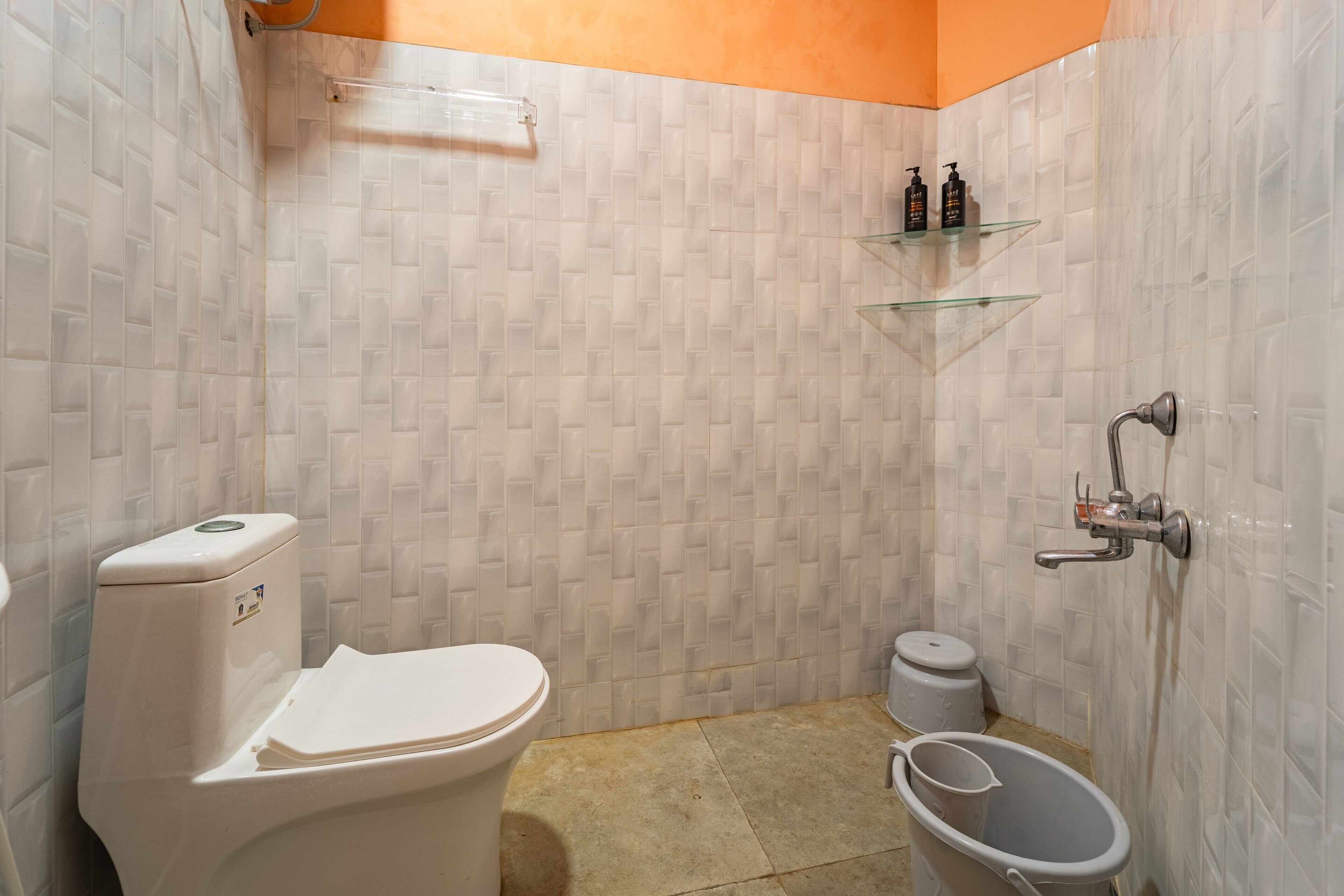 A bathroom with a toilet, bidet, and a small trash bin.