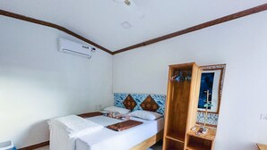 A bedroom with a bed, a wooden wardrobe, a mirror, and a small shelf with items. - Moro Rasdhoo (Rasdhoo)