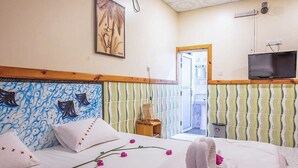 A hotel room with a bed, a television, a painting, and a window. - Moro Rasdhoo (Rasdhoo)