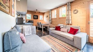 Ein gemütliches Wohnzimmer mit einer Couch, einem Esstisch und einer Küchenzeile.