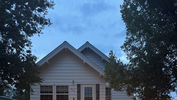 A two-story house with a front porch and steps leading to the door. - Red Roof Retreat - cozy home in Carson (Carson)