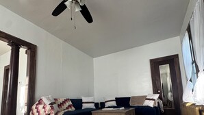 A living room with a dark blue sectional sofa, a wooden coffee table, and a patterned rug. - Red Roof Retreat - cozy home in Carson (Carson)