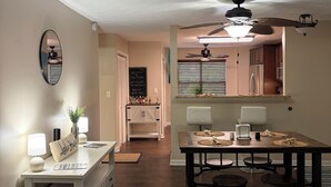 Cocina amplia con comedor, piso de madera, ventiladores de techo y vista al salón.
