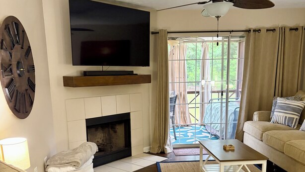 Una sala de estar con chimenea, televisor y zona de estar.