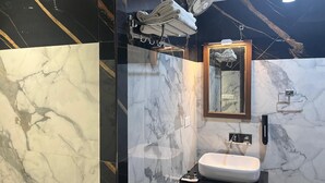 A modern bathroom with a marble vanity, a sink, and a mirror with a wooden frame. - Parvati Home Stay (Varanasi)