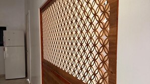 A hallway with a wooden partition featuring a geometric pattern.