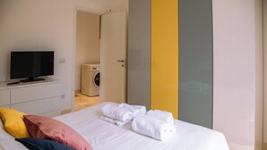 Een hotelkamer met een bed, een televisie, een wasmachine en een kledingkast.