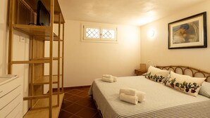 A bedroom with a bunk bed, a single bed with a cactus-themed pillow, a framed picture on the wall, and a window with a lattice design. - Villa VILLACOLLE - Marsala (Marsala)