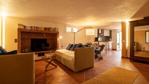 A living room with a fireplace, sofa, and a dining area with a table and chairs. - Villa VILLACOLLE - Marsala (Marsala)