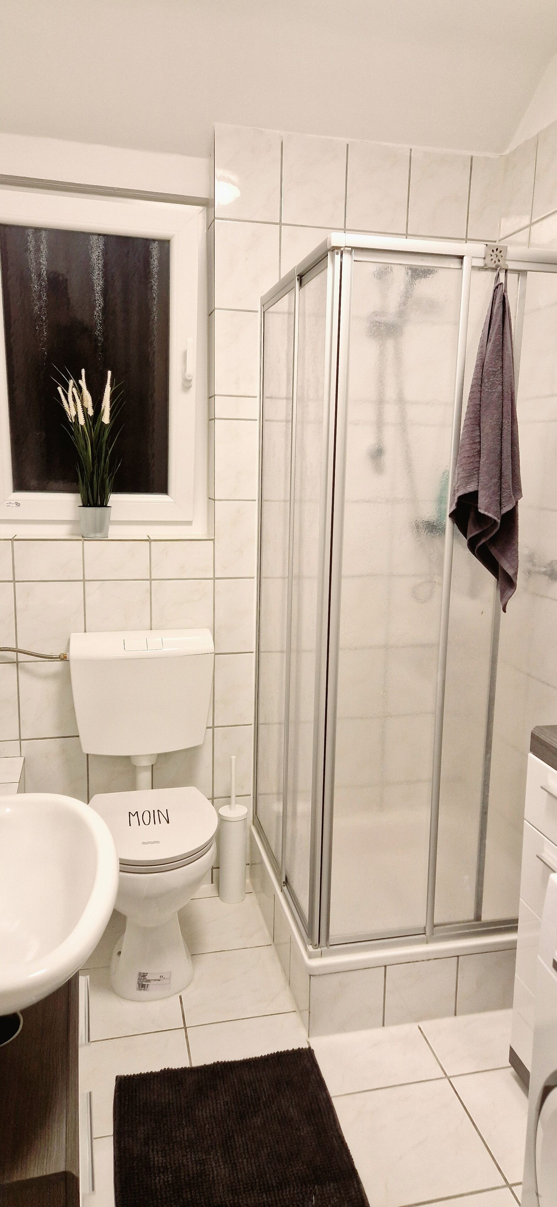 A bathroom with a toilet, sink, and shower.