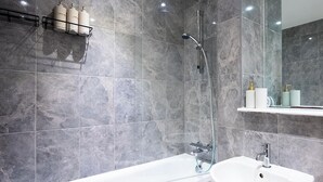 Un baño moderno con bañera, lavamanos y ducha.