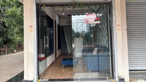 A hotel reception area with a glass entrance, a reception desk, and a staircase leading inside. - Hotel Fortune (Indore)
