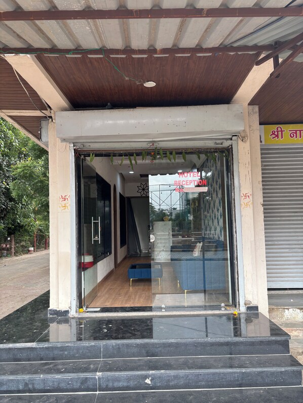 A hotel reception area with a glass entrance, a reception desk, and a staircase leading inside. - Hotel Fortune (Indore)