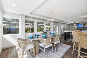 A dining area with a large table, chairs, and a television. - Sarasota Retreat with Private Pool near Siesta Key - 3-Bedroom 4.5-Bathroom (Sarasota)