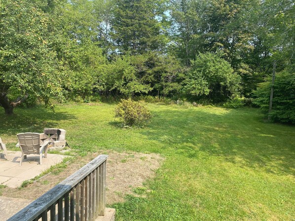 A backyard with a wooden deck, a small bush, and a grassy lawn. - Stillwood Grove - A cozy 2 bed house, Close to Sensea Spa and Coveside Stables (Chester)