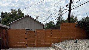 A gated driveway leading to a building with a garage.