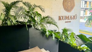 A modern hotel entrance with a sign for 'Kumarú Suites'. - Modern Studio, Pool, WiFi, min Sea and 5th Ave. (Playa del Carmen)